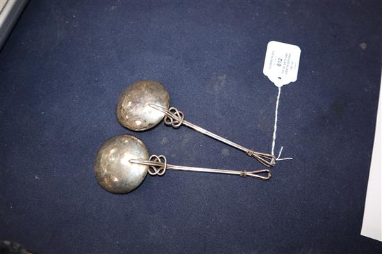 A pair of Arts and Crafts white metal serving spoons, with pierced scroll stems and openwork terminals, 17.2cm.